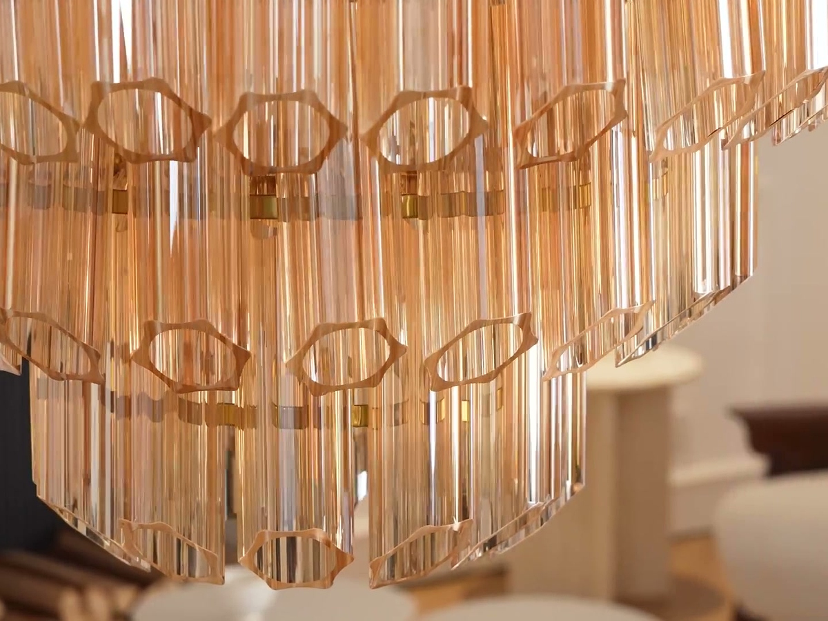 Macro detail of mouth-blown hexagonal fluted crystal prisms and brass retention bands on Aurum Cascade chandelier